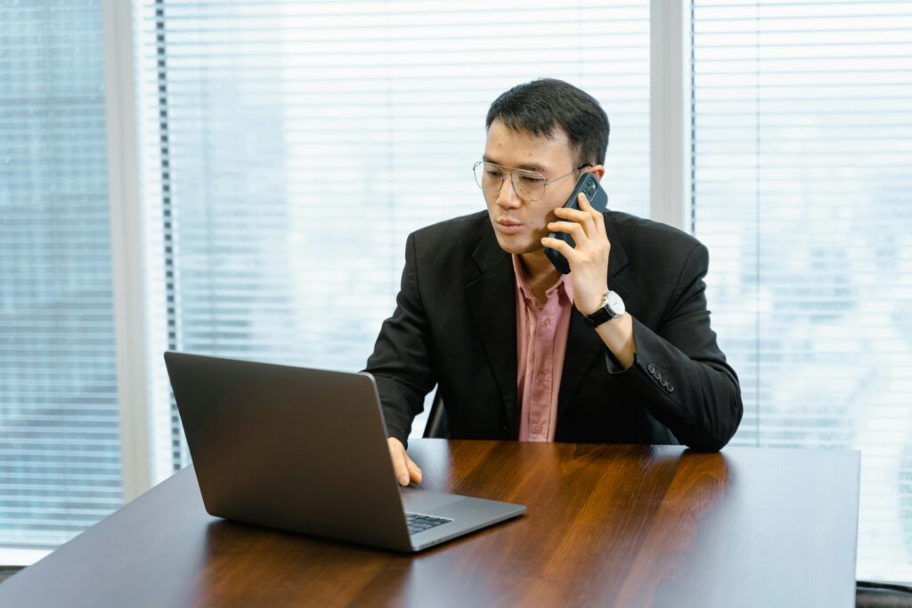 Business professional taking a phone call at a desk